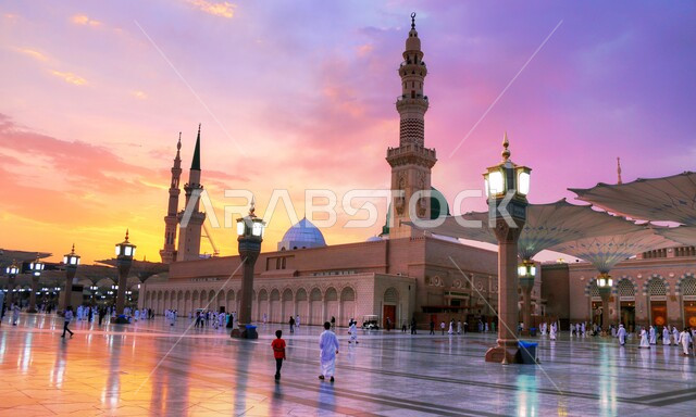 العبادة والتقرب الى الله تعالى ، تجول المصلين في المجمع الخارجي للمسجد النبوي في وقت الغروب، المظلات الالكترونية في ساحة الحرم النبوي الشريف في المدينة المنورة بالمملكة العربية السعودية، المعالم والأماكن الاسلامية المقدسة