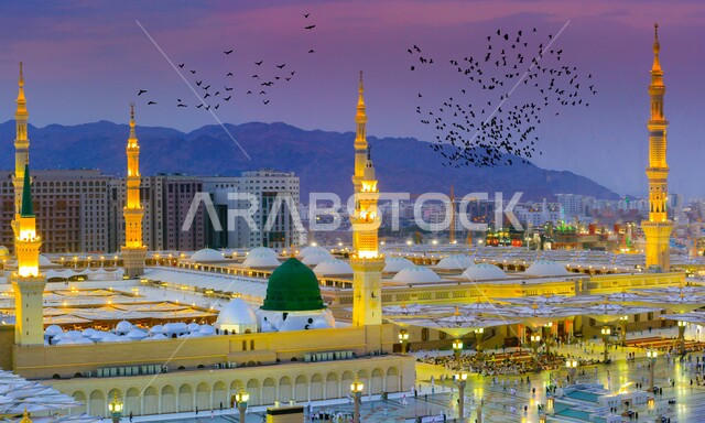 المعالم والأماكن الدينية الإسلامية المقدسة ، القبة الخضراء والمآذن المضيئة في الروضة الشريفة عند غروب الشمس، صورة جوية علوية للمسجد النبوي بالمدينة المنورة بالمملكة العربية السعودية