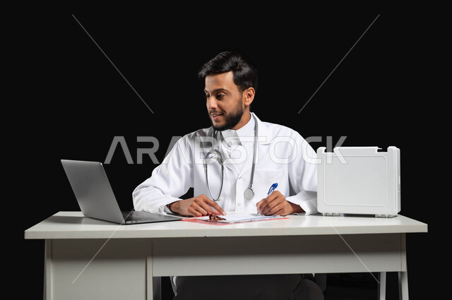 تدوين التقارير والحالات الصحيه، تقديم الخدمات الطبية للمرضى و متابعة حالاتهم, استخدام حقيبة الاسعافات الاوليه، بورتريه لطبيب عربي خليجي سعودي مبتسم يرتدي المعطف و السماعة الطبية يقوم باستعمال الحاسوب المحمول، خلفية سوداء, محتوى حساس, استخدام حساس