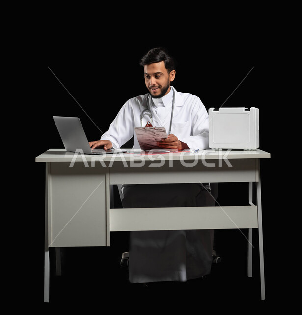 دراسة حالات المرضى عبر الاجهزة و التقنيات الحديثة, تقديم الخدمات الطبية, دمج العمل مع التكنولوجيا, بورتريه لطبيب عربي خليجي سعودي يرتدي المعطف الأبيض وسماعة الأذن يقوم باستعمال جهاز الحاسوب المحمول، استخدام حقيبة الاسعافات الاوليه، خلفية سوداء, محتوى حساس, استخدام حساس