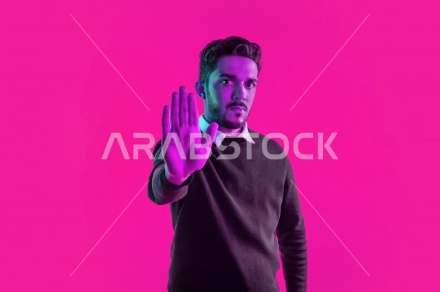 بورتريه لرجل سعودي خليجي غاضب و عابس بإيماءات وجه و يدين مختلفة  ، تعابير وجه و يدين مختلفة ، خلفية ملونة