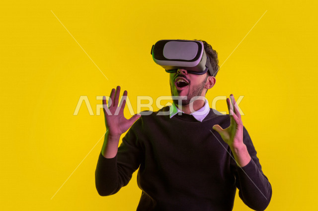 بورتريه رجل سعودي خليجي سعيد ،يضع جهازVR Box، ايماءات وجه و يدين تدل على السعادة و الاستمتاع ، استخدام تقنية ثلاثية الابعاد ، خلفية ملونة