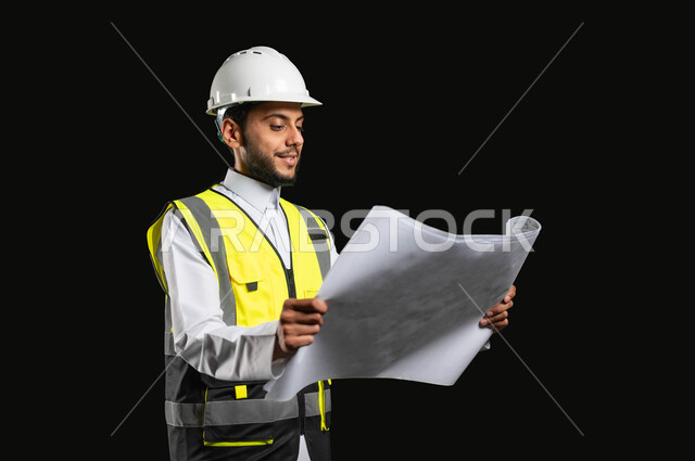 مهن ووظائف ضمن القطاع الهندسي في السعوديه، بورتريه مقرب لمهندس عربي خليجي سعودي مبتسم يرتدي الزي التقليدي مع سترة الحماية والخوذة يقوم بادارة المشاريع وتدقيقها، خلفية سوداء,محتوى حساس، استخدام حساس