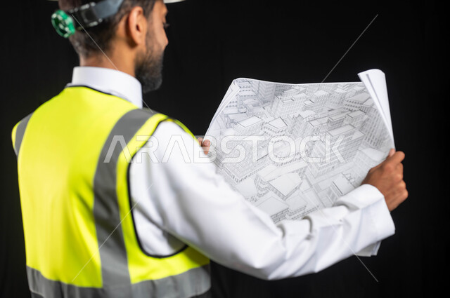 Working in the engineering sector, the concept of project management and auditing, a portrait of a Saudi Arabian Gulf engineer wearing a traditional uniform with a protective jacket and helmet, following up on the work and project plans, black background, sensitive content, sensitive use