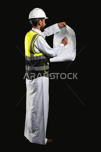 Working in the engineering sector, the concept of project management and auditing, a portrait of a Saudi Arabian Gulf engineer wearing a traditional uniform with a protective jacket and helmet drawing project plans, full-length body image, black background, sensitive content, sensitive use