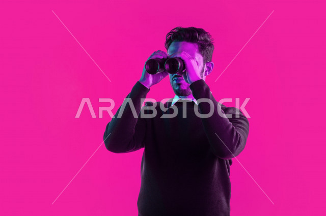 بورتريه رجل سعودي خليجي مستكشف ، يستخدم الناظور، البحث والاستكشاف ، خلفية ملونة