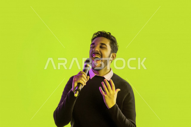 بورتريه رجل سعودي خليجي سعيد ،  يحمل الميكروفون و يقوم بالغناء  ، ايماءات وجه و يدين تدل على السعادة و الاستمتاع ، موهبة الغناء ، خلفية ملونة