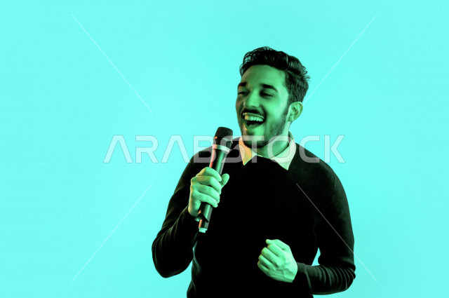 بورتريه رجل سعودي خليجي سعيد ،  يحمل الميكروفون و يقوم بالغناء  ، ايماءات وجه و يدين تدل على السعادة و الاستمتاع ، موهبة الغناء ، خلفية ملونة