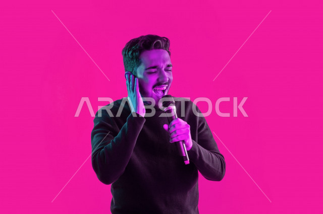 Portrait of a happy Saudi Gulf man, carrying a microphone and singing, face and hand gestures indicating happiness and enjoyment, singing talent, colorful background
