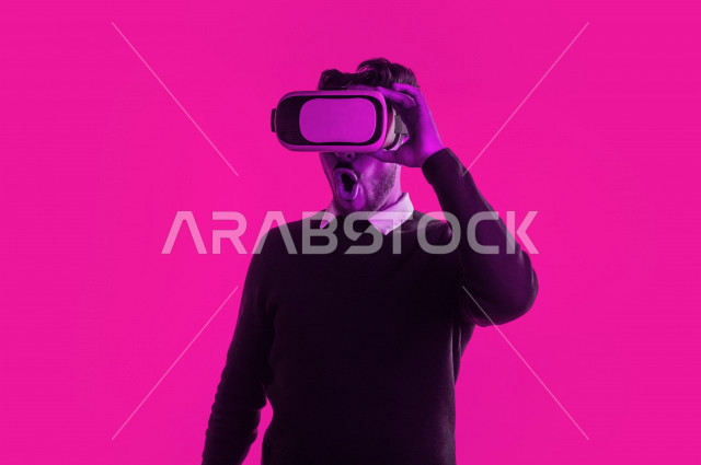 بورتريه رجل سعودي خليجي سعيد ،يضع جهازVR Box، ايماءات وجه و يدين تدل على السعادة و الاستمتاع ، استخدام تقنية ثلاثية الابعاد ، خلفية ملونة