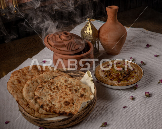 مقبلات عربية باردة مع أواني فخارية، وجبة فطور صحية, مأكولات عربية تقليدية, أطعمة صحية غنية بالبروتينات, أطباق المتبل والفتات، أرغفة الخبز الطازجة