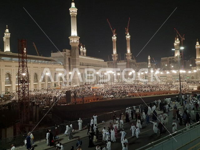 تجمع زوار بيت الله الحرام في الفناء الخارجي للمسجد الحرام ليلا, قدوم المسلمين من جميع أنحاء العالم إلى الاماكن المقدسة في المملكة, المعالم الاسلامية الدينية المشهورة, دخول المصلين الى الجامع لأداء المناسك والعبادات والتقرب الى الله