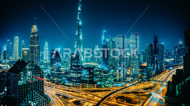 حركة المرور في الشوارع والطرقات في وقت المساء، التقدم والتوسع العمراني، الفن الهندسي المعماري للمباني والمنشآت السكنية، صورة جوية للأبراج وناطحات السحاب المضاءة في دولة الإمارات العربية المتحدة، معالم دبي السياحية