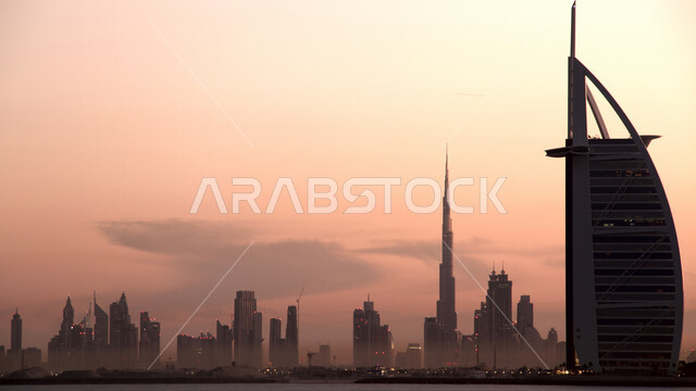 منظر السماء وقت غروب الشمس، النمو والتطور العمراني على ساحل الخليج العربي، صورة ظليلية لبرج العرب في امارة دبي، الفن الهندسي المعماري للأبراج وناطحات السحاب، جذب واستقطاب السياح من انحاء العالم
