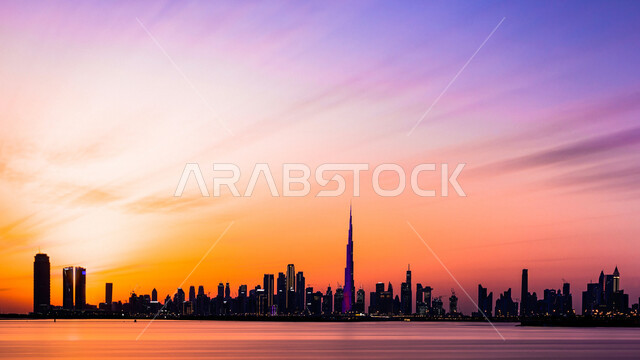 الواجهة البحرية على ساحل الخليج العربي، النمو والتقدم والتوسع العمراني، الفن الهندسي المعماري للمباني والمنشآت المطلة على البحر الإصطناعي، صورة ظليلية للأبراج وناطحات السحاب في دولة الإمارات العربية المتحدة في وقت غروب الشمس، معالم دبي السياحية