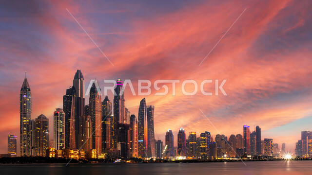 الواجهة البحرية على ساحل الخليج العربي، النمو والتقدم والتوسع العمراني، الفن الهندسي المعماري للمباني والمنشآت المطلة على البحر، منظر الأبراج وناطحات السحاب في دولة الإمارات العربية المتحدة وقت غروب الشمس، معالم دبي السياحية