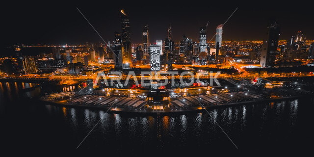 Architectural engineering art of towers and skyscrapers, waterfront of Kuwait City, aerial photo of hotels and residential facilities illuminated at night, famous tourist attractions