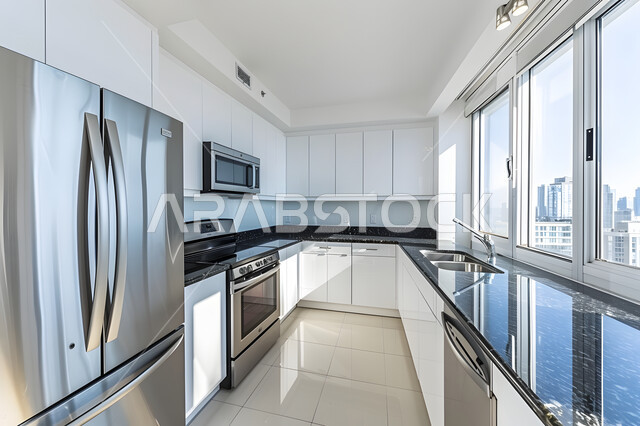 أدوات منزلية حديثة بتقنيات عالية، التصميم الهندسي الكلاسيكي للمطابخ، الفلل والشقق السكنية في المملكة العربية السعودية، نوافذ وواجهات زجاجية مطلة على المباني والأبراج، مطبخ فاخر وراقي باللون الأبيض 