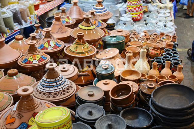 Pottery utensils and products made of clay, a store selling pottery utensils in the traditional popular market in the city of Abha in the Asir region, ancient traditional folk crafts and crafts in the Kingdom of Saudi Arabia, buying souvenirs and colorful and decorated pottery.