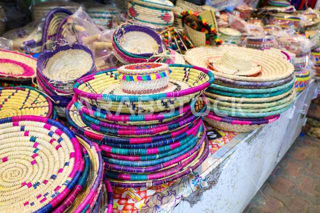 متجر لبيع الصناعات اليدوية الشعبية التقليدية بالمملكة العربية السعودية، صورة مقربة لسلل القش والمنتجات المحلية الوطنية، اقتناء الهدايا التذكارية الملونة والمزخرفة، المتاجر والاسواق الشعبية التقليدية، اواني الخوص الطبيعي في سوق مدينة أبها في منطقة عسير،