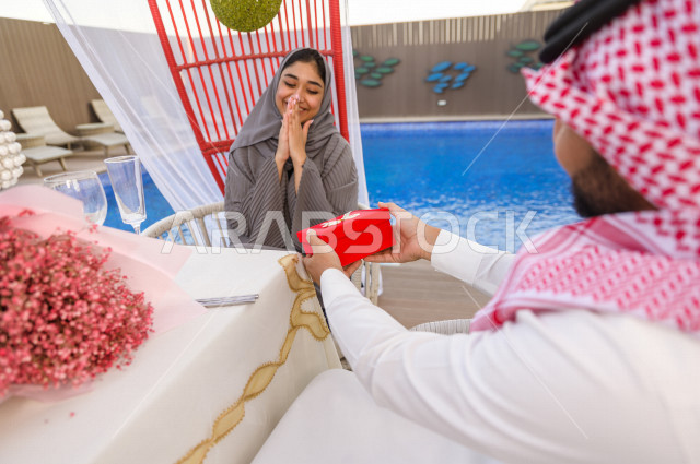زوجان سعوديان يحتفلان بيوم زواجهم بتقديم الهدايا والورد في أحد المنتجعات الخليجية  , يوم الحب , ذكرى زواج , جلسات رومانسية . 