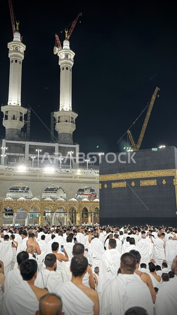 مآذن المسجد الحرام في مكة المكرمة بالمملكة العربية السعودية ، أداء مناسك الحج والعمرة، العبادة والتقرب إلى الله تعالى، معالم دينية إسلامية مقدسة في الليل، الحجاج والمعتمرين في ساحة الحرم المكي الشريف