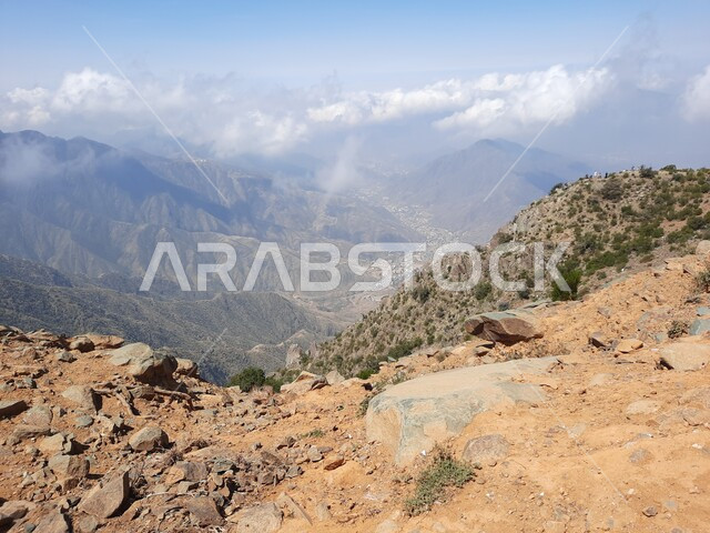 التكوينات والتشكيلات الجبلية الصخرية في مدينة ابها في المملكة العربية السعودية، مدن وأماكن سياحية طبيعية، نمو الأعشاب البرية والنباتات الخضراء في القمم والمرتفعات، منظر الغيوم البيضاء في اجواء فصل الصيف في عسير