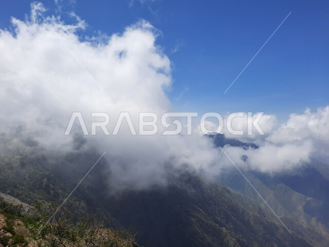 منظر الغيوم البيضاء في اجواء فصل الصيف في عسير، التشكيلات والتكوينات الجبلية الصخرية في مدينة ابها في المملكة العربية السعودية، مدن وأماكن سياحية طبيعية، نمو الأعشاب البرية والنباتات الخضراء في القمم والمرتفعات