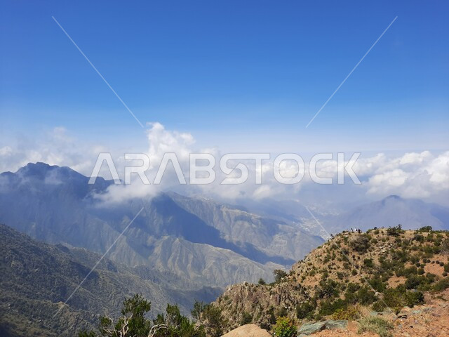 منظر الغيوم البيضاء في اجواء فصل الصيف في عسير، التشكيلات والتكوينات الجبلية الصخرية في مدينة ابها في المملكة العربية السعودية، مدن وأماكن سياحية طبيعية، نمو الأعشاب البرية والنباتات الخضراء في القمم والمرتفعات