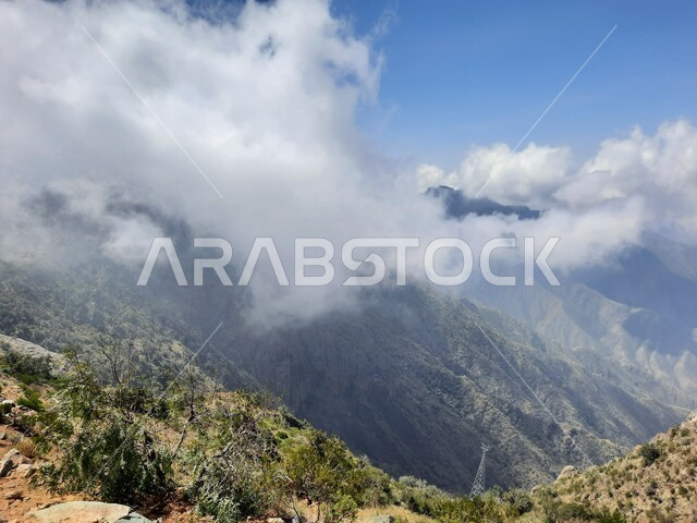 منظر الغيوم البيضاء في اجواء فصل الصيف في عسير، التشكيلات والتكوينات الجبلية الصخرية في مدينة ابها في المملكة العربية السعودية، مدن وأماكن سياحية طبيعية، نمو الأعشاب البرية والنباتات الخضراء في القمم والمرتفعات