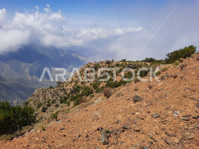 السحب والغيوم البيضاء في سماء عسير، التكوينات والتشكيلات الجبلية الصخرية في مدينة ابها، مدن وأماكن سياحية طبيعية في المملكة العربية السعودية، نمو الأعشاب البرية والنباتات الخضراء في القمم والمرتفعات