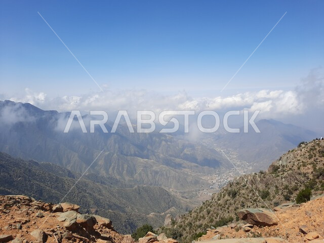 التشكيلات والتكوينات الجبلية الصخرية في مدينة ابها في المملكة العربية السعودية، مدن وأماكن سياحية طبيعية، نمو الأعشاب البرية والنباتات الخضراء في القمم والمرتفعات، منظر الغيوم البيضاء في اجواء فصل الصيف في عسير