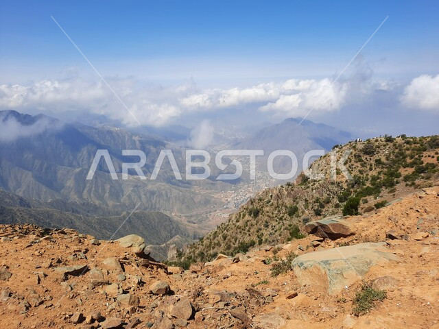 التشكيلات والتكوينات الجبلية الصخرية في مدينة ابها في المملكة العربية السعودية، مدن وأماكن سياحية طبيعية، نمو الأعشاب البرية والنباتات الخضراء في القمم والمرتفعات، منظر الغيوم البيضاء في اجواء فصل الصيف في عسير