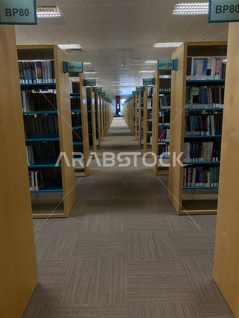  مكتبة جامعة الملك فيصل المركزية في مدينة الهفوف في المملكة العربية السعودية، الممرات بين الأرفف المليئة بالكتب، قاعات تخزين الكتب والأبحاث العملية، أماكن للمطالعة وزيادة الثقافة والمعرفة، مركز الملك فيصل للبحوث والدراسات الإسلامية