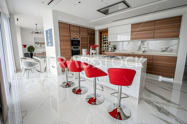 فنون الهندسة المعمارية المتميزة الحديثة، مطبخ بخزائن خشبية، ديكورات داخلية عصرية فاخرة، شقق وفلل سكنية في المملكة العربية السعودية، الطراز الفني الراقي في الأثاث المنزلي، طاولة رخامية مستطيلة وكراسي باللون الأحمر