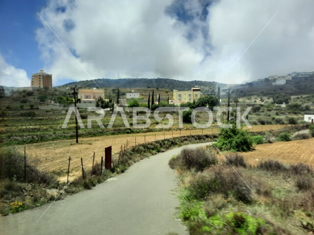 منظر السحب والغيوم البيضاء في السماء، القمم والمرتفعات الجبلية في مدينة ابها، مدن وأماكن سياحية طبيعية في المملكة العربية السعودية، القرى السكنية والبيوت والمنازل المبنية أعلى الجبل، الحقول والواحات الزراعية والنباتات الخضراء في جبال عسير