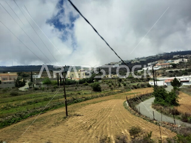 The view of clouds and white clouds in the sky, the mountain peaks and heights in the city of Abha, cities and natural tourist places in the Kingdom of Saudi Arabia, residential villages, homes and homes built on top of the mountain, agricultural fields and oases and green plants in the Asir Mountains.