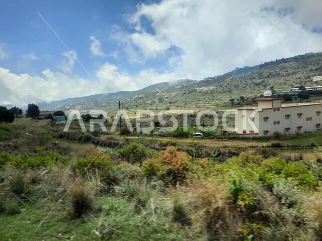 المدرجات الزراعية والحقول والنباتات الخضراء في جبال عسير، منظر السحب والغيوم البيضاء في السماء، القمم والمرتفعات الجبلية في مدينة ابها، مدن وأماكن سياحية طبيعية في المملكة العربية السعودية، القرى السكنية والبيوت والمنازل المبنية أعلى الجبل