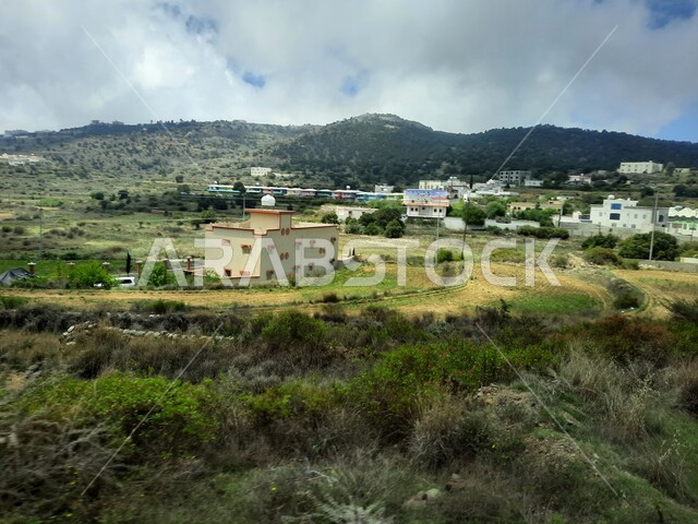 المدرجات الزراعية والحقول والنباتات الخضراء في جبال عسير، منظر السحب والغيوم البيضاء في السماء، القمم والمرتفعات الجبلية في مدينة ابها، مدن وأماكن سياحية طبيعية في المملكة العربية السعودية، القرى السكنية والبيوت والمنازل المبنية أعلى الجبل