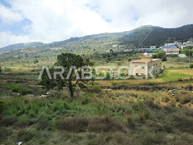 المدرجات الزراعية والحقول والنباتات الخضراء في جبال عسير، منظر السحب والغيوم البيضاء في السماء، القمم والمرتفعات الجبلية في مدينة ابها، مدن وأماكن سياحية طبيعية في المملكة العربية السعودية، القرى السكنية والبيوت والمنازل المبنية أعلى الجبل