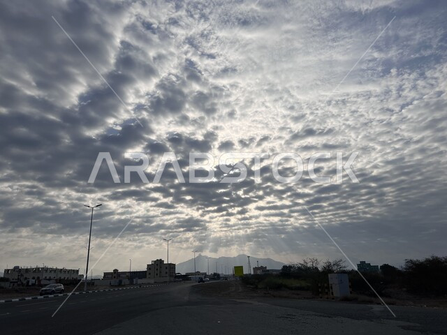  منظر الغيوم والسحب البيضاء المتجمعة فوق مدينة العيدابي شرق منطقة جازان، الطرق والشوارع الاسفلتية المعبدة، الاهتمام بالبنية التحتية في المدن والمناطق السياحية في المملكة، مشهد شروق الشمس في سماء السعودية