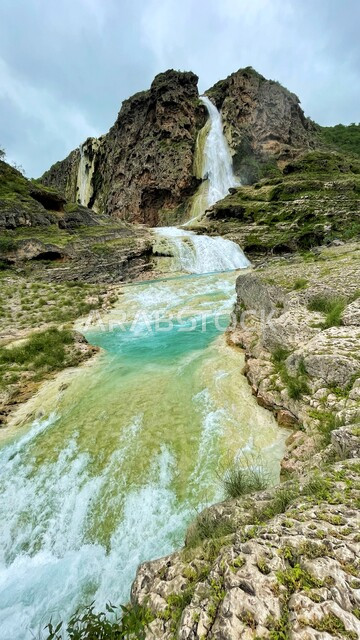 الشلالات المائية الطبيعية على السفوح والمنحدرات، شلال عين كور في ولاية صلالة في سلطنة عمان، نمو النباتات الخضراء والأعشاب على الجبال, مناطق سياحية لقضاء أوقات ممتعة، خلفية الطبيعه