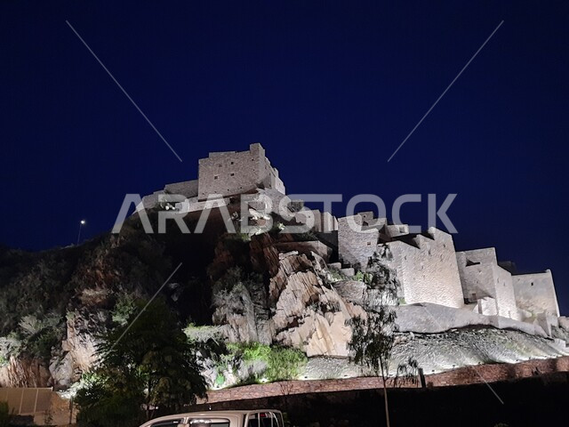 Rock formations and formations in mountainous areas at night, architectural engineering art of houses and stone buildings built on the slopes of mountains, tourist attractions in the Kingdom of Saudi Arabia, the historic village of Dhi Al Ain in the Al Bahah region