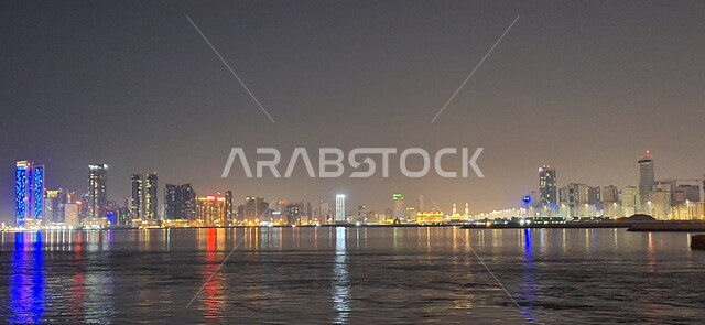 Illuminated towers, buildings and skyscrapers overlooking the coast of the Arabian Gulf, famous recreational tourist places in the State of Bahrain, the waterfront of the city of Manama in Bahrain at night, tranquil seascapes