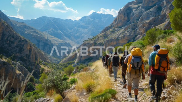 مفهوم حب المغامرات والاستكشاف، التشكيلات والتكوينات الصخرية في المملكة العربية السعودية، الاستمتاع بالمناظر الطبيعيه في الجبال، صورة من الخلف لمجموعة من السياح يسيرون في القمم والمرتفعات الجبلية في وقت النهار