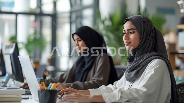 إدارة شؤون العمل وتنظيمها، مهن ووظائف إدارية سعودية، مجموعة من سيدات الأعمال العربيات الخليجيات السعوديات المحجبات يجلسون في مكتب أمام الحواسيب المحمولة، دمج التقنيات الحديثة والمتطورة بالأعمال المكتبية