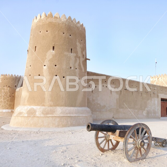 مدفع حربي قديم امام مبنى قلعة الزبارة غرب مدينة الدوحة في النهار، القلاع والحصون القطرية, معالم سياحية مشهورة، مواقع تاريخية أثرية في دولة قطر, الفن الهندسي المعماري على الطراز القديم ببقلاع التراثية العسكرية