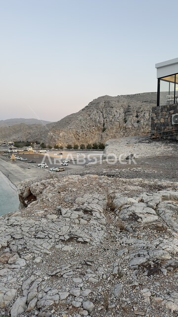 موقف سيارات الزوار بجانب التكوينات الجبلية على شاطئ سلطنة عمان، الاستمتاع بمنظر البحر في النهار، رحلات ترفيهية سياحية على الواجهات البحرية، أماكن و معالم طبيعية سياحية