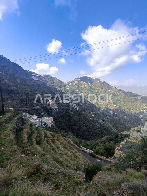  الغيوم والسحب البيضاء فوق القمم والمرتفعات الجبلية في محافظة فيفاء، المدرجات الزراعية والبيوت والمباني السكنية في مدينة جازان، الأشجار والنباتات الخضراء المزروعة على سفوح الجبال, الاستمتاع بالمناظر الطبيعية في الأماكن السياحية في المملكة العربية السعودية