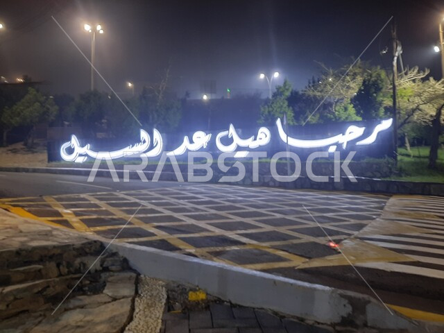 عبارة ترحيبية مضيئة على بوابة منتزه غابة رغدان في مدينة الباحة، الاهتمام بإنارة إضاءة الحدائق العامة، التشجير وزراعة النباتات الخضراء في مدن المملكة العربية السعودية، أماكن طبيعية عائلية ترفيهية، قضاء وقت ممتع في الطبيعة والهواء الطلق